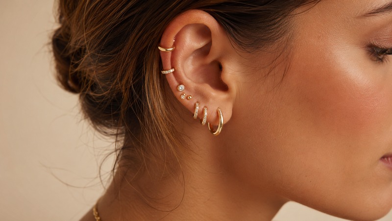 Curated ear stacks combine huggies, studs, cuffs, and mini hoops