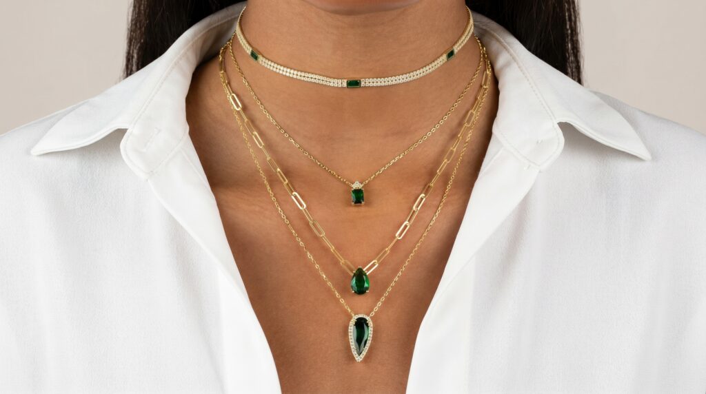 Jewelry featuring gemstones like emeralds, crafted into pendants and necklaces.